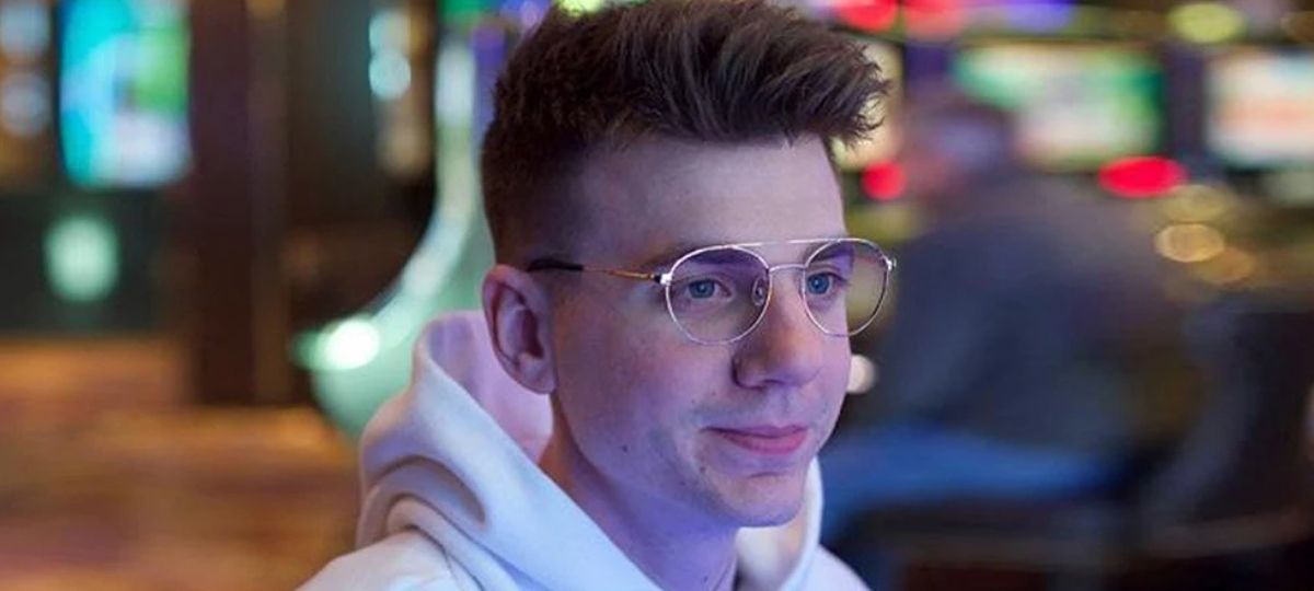 A young man wearing gaming glasses in public at night