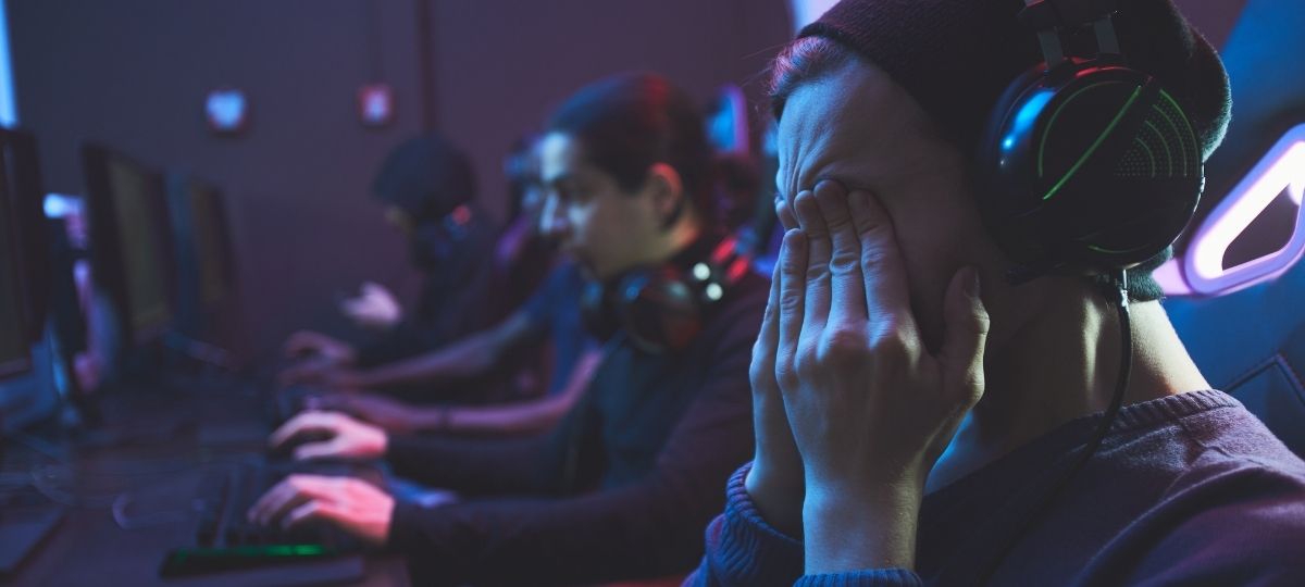 Professional Gamer Sitting In a Dark Room playing video games intensely