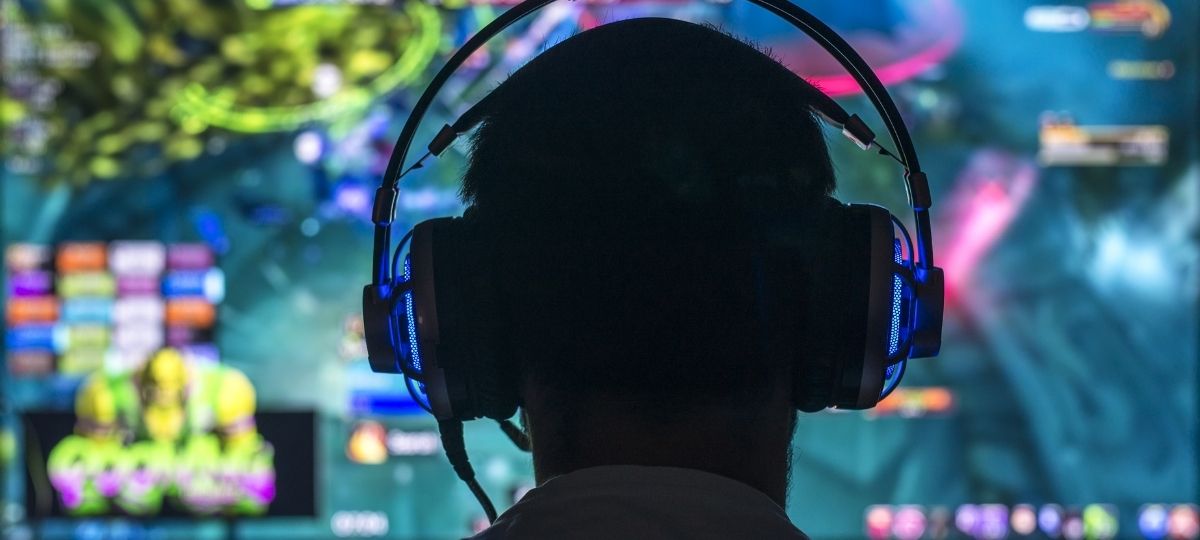 a photo from behind of a gamer looking into their monitor
