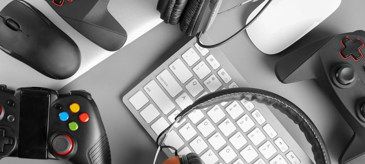 A group photo of a keyboard, controller, mouse and headset on a gaming desk