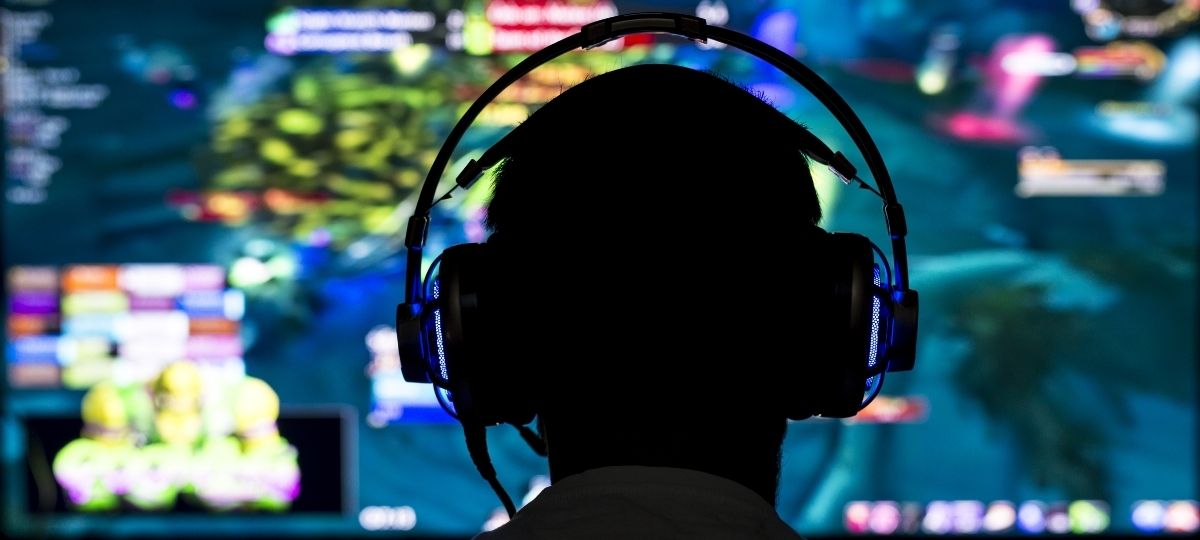 A photo from behind while someone sets at a computer intensely playing video games