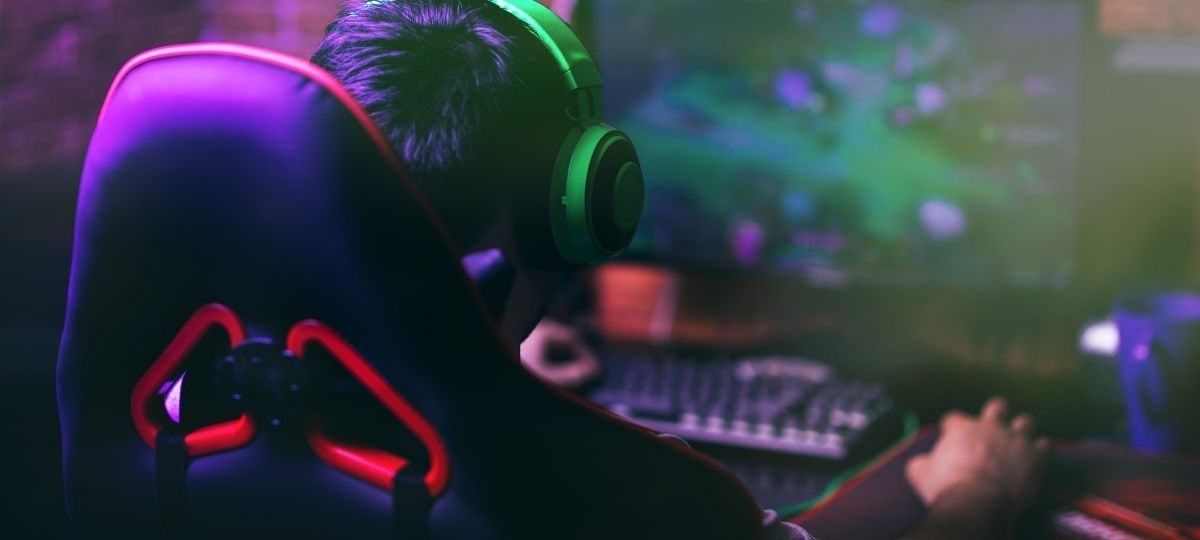 A photo showing a professional gamer playing on their computer from behind
