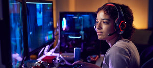 A young woman playing video gaming on her computer in her dark room