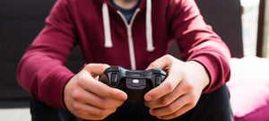 a close up photo of someone holding a gaming controller while in their living room