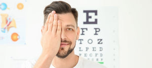 A young man getting an eye exam while covering his right eye