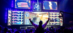 professional gamer cheering in front of multiple monitors at a competition